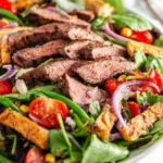 Southwest flank steak salad with avocado dressing in a large bowl