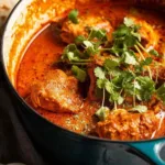 African Chicken Curry Kuku Paka served in a bowl with basmati rice and fresh cilantro