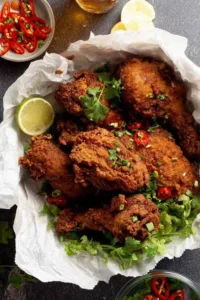 Ayam Goreng Malaysian Fried Chicken on a platter with crispy golden crust and cilantro garnish