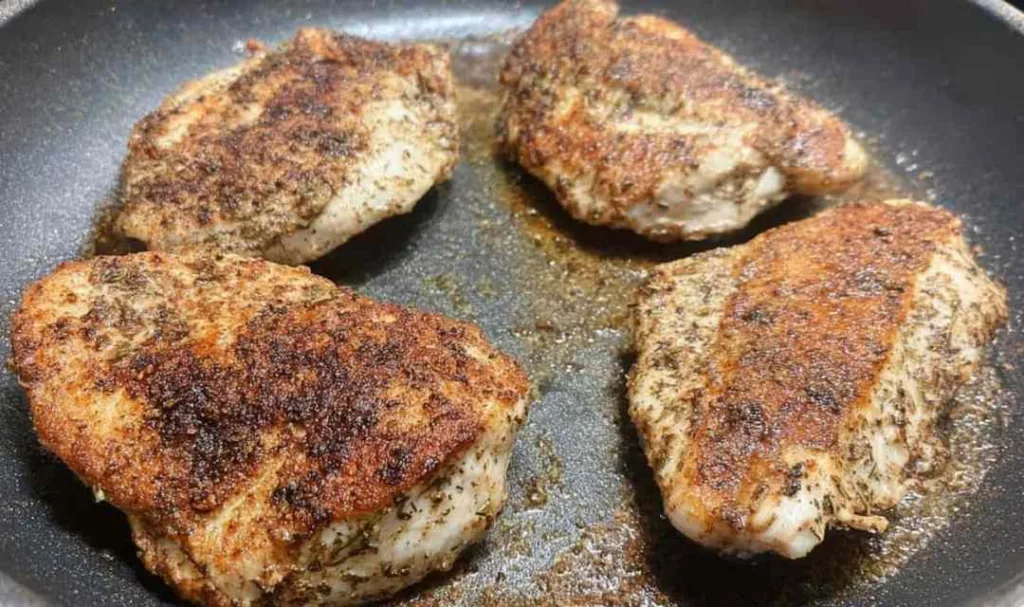 Homemade chicken alfredo with sliced golden chicken breast over creamy fettuccine in a white bowl