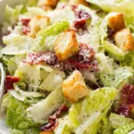 Chicken Caesar salad with homemade dressing served in a white bowl