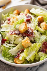 Chicken Caesar salad with homemade dressing served in a white bowl