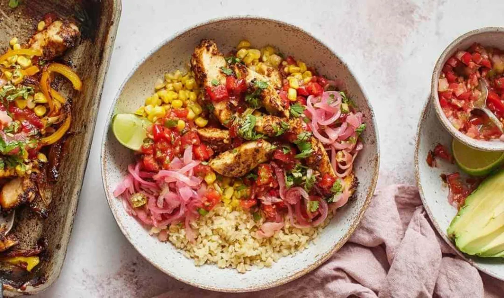 Chicken fajita bowls with seasoned chicken, roasted bell peppers, corn, and pico de gallo served over white rice