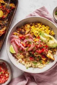 Chicken fajita bowls with seasoned chicken, roasted bell peppers, corn, and pico de gallo served over white rice