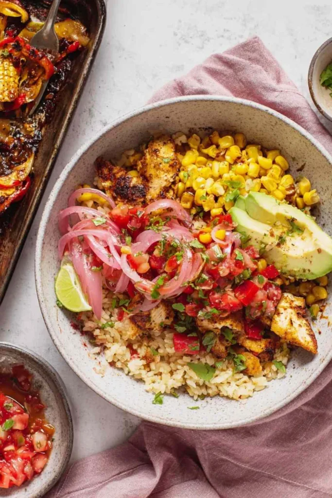 Chicken fajita bowls with seasoned chicken, roasted bell peppers, corn, and pico de gallo served over white rice
