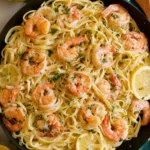 Creamy lemon shrimp pasta served on a white oval platter with fresh parsley garnish