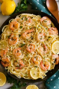 Creamy lemon shrimp pasta served on a white oval platter with fresh parsley garnish