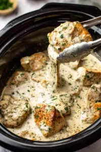 Crock Pot Garlic Parmesan Chicken served over spaghetti in a white bowl with fresh basil
