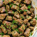 Garlic herb butter steak bites seared in cast iron skillet with fresh parsley