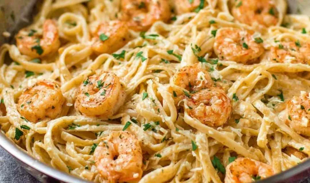 creamy garlic shrimp pasta in skillet with linguine and fresh parsley