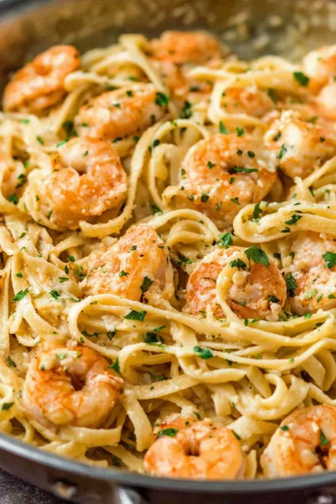 creamy garlic shrimp pasta in skillet with linguine and fresh parsley