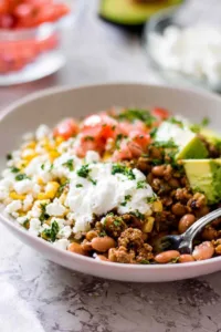 Ground turkey taco bowl with lime rice, avocado, queso fresco and sour cream