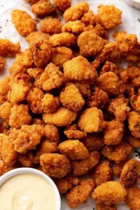 crispy KFC popcorn chicken recipe in a bowl with honey mustard dipping sauce