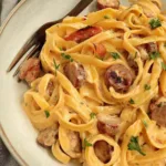 One Pot Creamy Cajun Sausage Pasta in a large skillet with colorful bell peppers and smoky sausage slices