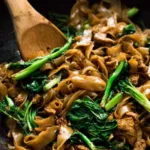 pad see ew thai stir fried noodles in wok caramelized