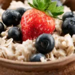 Superfood breakfast bowl slow cooker recipe topped with fresh berries and toasted almonds in a rustic bowl.