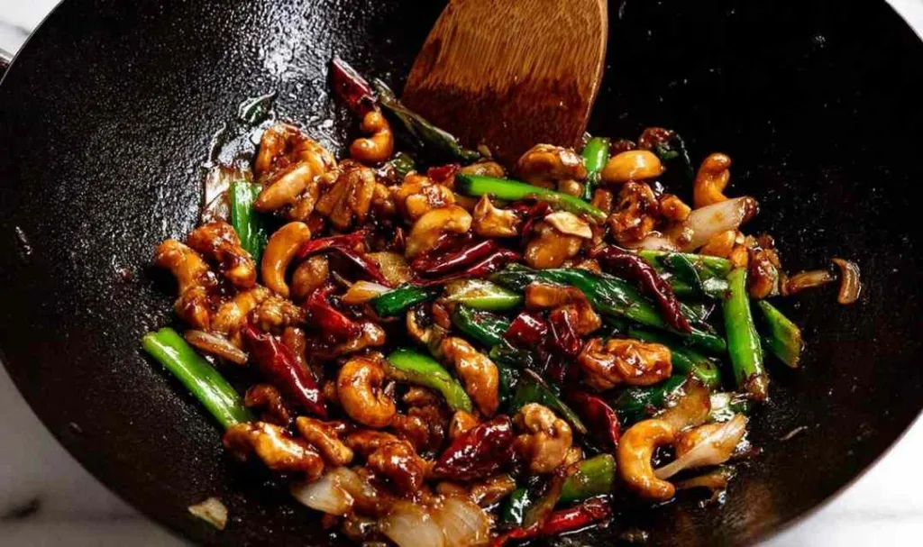 Thai cashew chicken stir fry served over jasmine rice in a white bowl