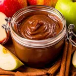 Homemade apple butter slow cooker recipe in mason jars with cinnamon sticks