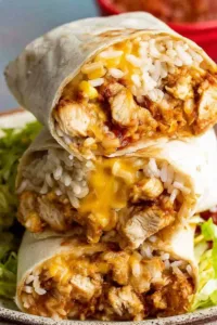 chicken burrito recipe cut in half showing juicy seasoned chicken refried beans and melted cheese