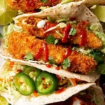 crunchy baked chicken taco fingers on warm flour tortillas with avocado slaw and sriracha