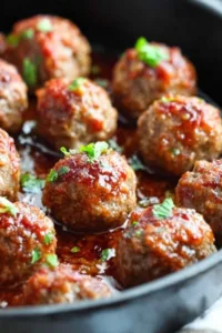 honey sriracha ground turkey meatballs garnished with sesame seeds and green onions on a white serving platter