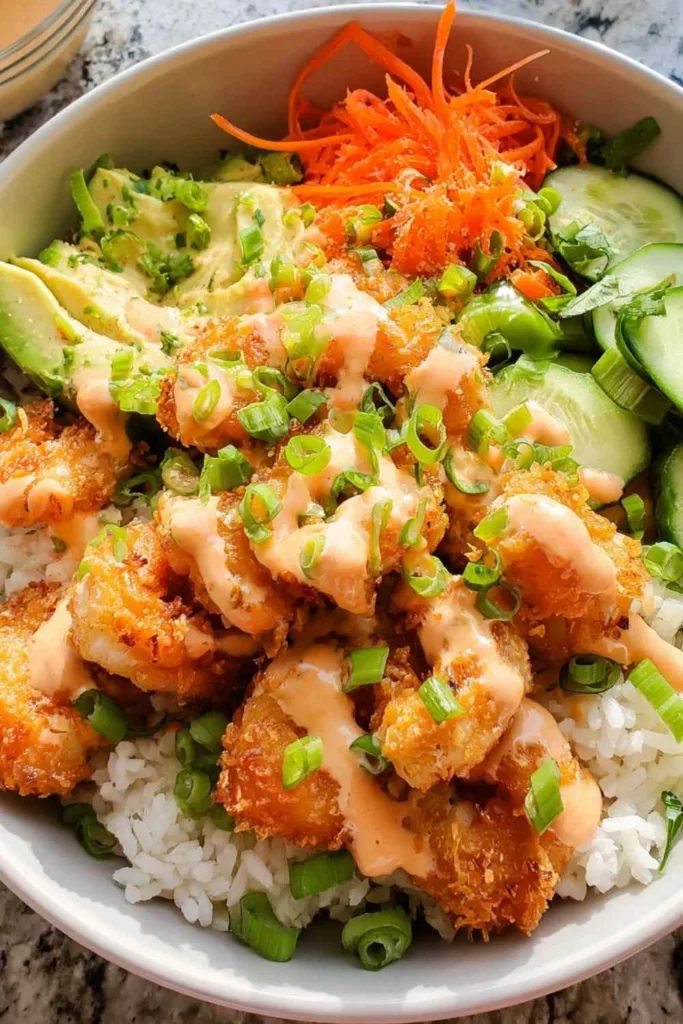 Bang Bang Shrimp Rice Bowl with crispy golden shrimp, avocado, edamame, carrots and bang bang sauce