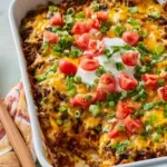Bubbling taco casserole with melted cheddar cheese in a 9x13 baking dish fresh from the oven