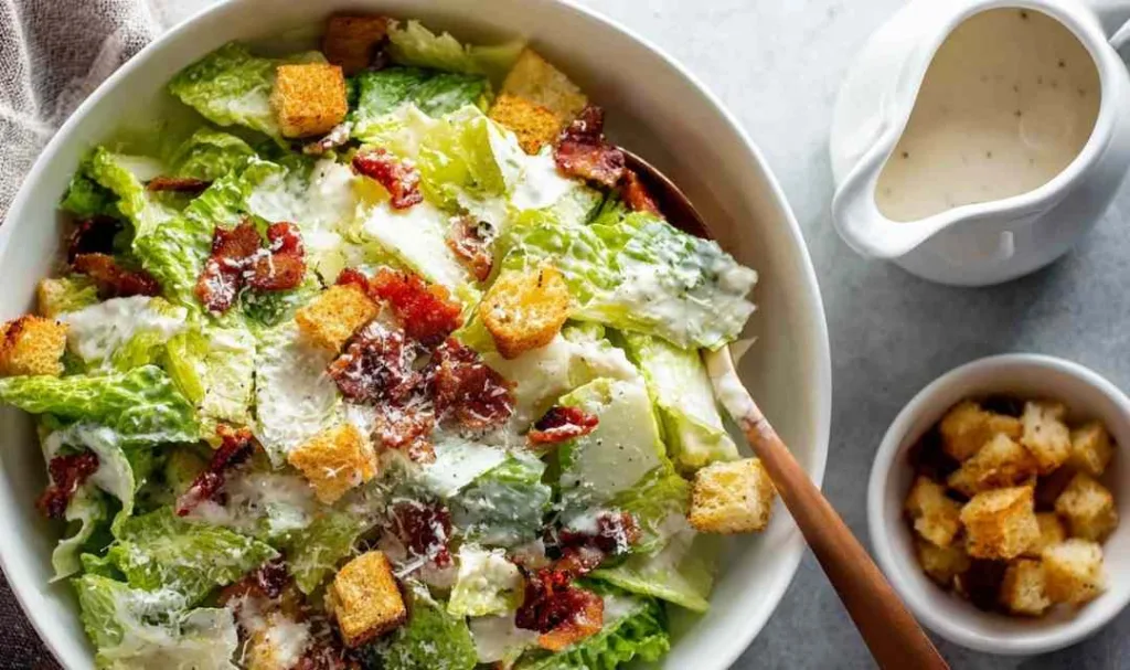 Classic chicken Caesar salad with homemade dressing, garlic croutons, and crispy bacon in a white bowl