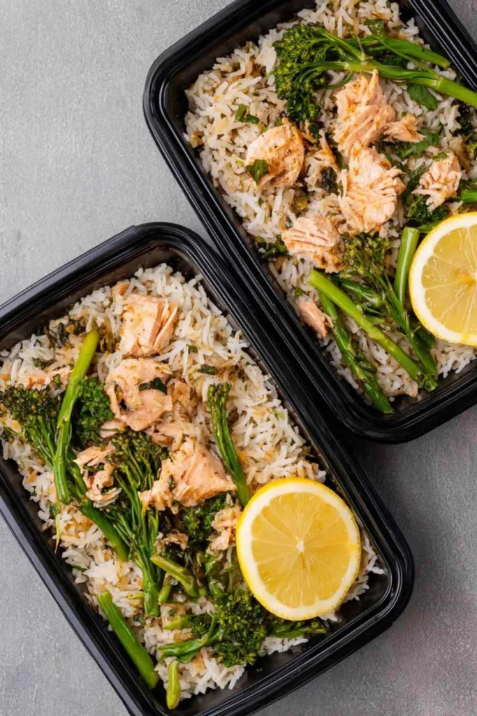 High protein salmon rice bowl with flaky salmon, jasmine rice, and asparagus in a meal prep container